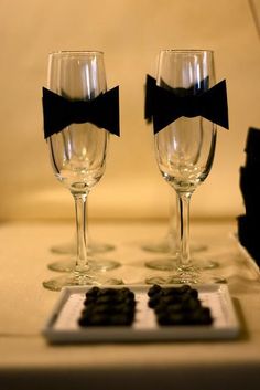 two wine glasses with black bows on them