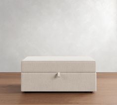 a white box sitting on top of a wooden floor