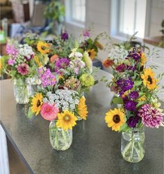 several vases filled with different types of flowers