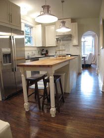 a kitchen with white cabinets and wooden floors