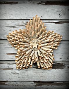 a wooden star shaped decoration on a wall made out of wood strips and plywood planks