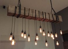 the light bulbs are hanging from the wooden beam in the room, which is decorated with wood planks and metal chains