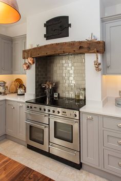 a stove top oven sitting inside of a kitchen next to a wooden shelf above it