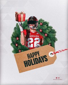 a football player holding a gift box with the words happy holidays written on it in front of a christmas wreath