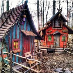 two wooden houses in the woods with colorful sidings