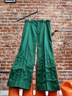 Mens 70s Green Psychedelic Pants with a Hint of Flare and Marigold Style Lines.  Amazing men's seventies green psychedelic pants cut with a hint of flare at the hem. Epic marigold style lines running up the front of the legs. Shorter style lines at the back of the hem. Contrasting marigold top stitching against this fantastic green. Front pockets and small back pockets with beautiful detail. Belt loops for your favorite seventies belt. Zipper fly with a snap button closure at the waist. The fabric is a non stretch blend with a slight sheen to it. These are statement pants for your psychedelic look. There is hem allowance for a longer inseam if you want to take the hem down and re hem. No tag. We do not know who made these incredible 70s pants. In perfect condition.  Measurements:  34" wais Retro Green Full-length Bottoms, Retro Full-length Green Bottoms, Vintage Green Wide-leg Bottoms, Retro Green Wide Leg Bottoms, 1970s Mens Fashion, 70s Pants, 70s Green, Flare Dress Pants, Statement Pants