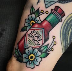 a tattoo with a bottle and flowers on it