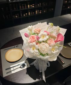 a bouquet of flowers sitting on top of a table next to a plate and knife