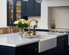 a kitchen with blue cabinets and white counter tops