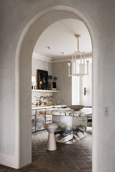 an archway leading into a kitchen with marble counter tops