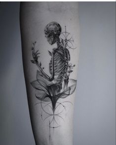 a black and white photo of a skeleton with flowers on it's leg, done by