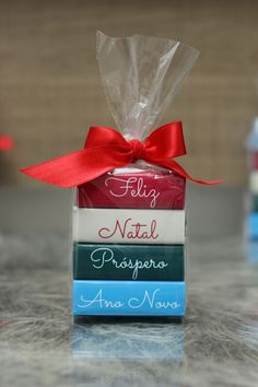 three books wrapped in cellophane and tied with a red ribbon on a counter