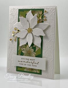 a card with white poinsettis on green and white paper, says it's the most wonderful time of the year