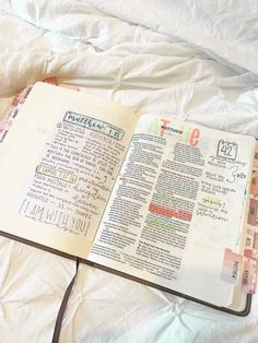 an open bible laying on top of a bed