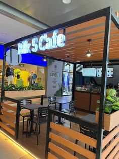 the inside of a restaurant with wooden benches and tables under a awning that reads bike's cafe