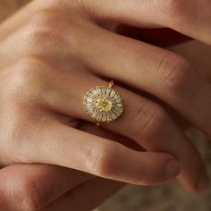 a woman's hand with a yellow diamond ring on top of her left hand