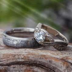 two wedding rings sitting on top of a tree branch