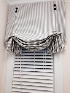 a window with a striped valance hanging from it's side