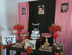 a table topped with cakes and desserts covered in red flowers