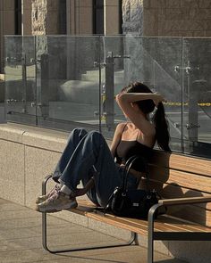 a woman sitting on a bench with her head in her hands and looking off to the side