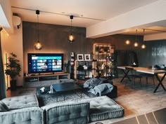 a living room filled with furniture and a large flat screen tv mounted to the wall