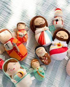 several small dolls are arranged on a bed