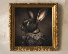 a painting of a rabbit wearing a dress with an ornate gold frame hanging on the wall