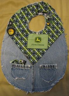 an old pair of jeans with patches and buttons on them are used to make a baby bib