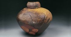 a brown vase sitting on top of a table