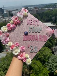 a pink graduation cap that says new stop howard'28 on it with flowers around it