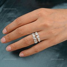 a woman's hand with three diamond rings on top of her ring, and the middle