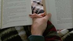 a person is reading a book while laying down