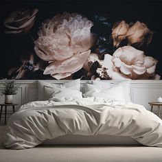 a bed with white sheets and pillows in front of a large floral wall mural on the wall