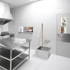 an empty kitchen with stainless steel appliances and white tile flooring in the middle of it