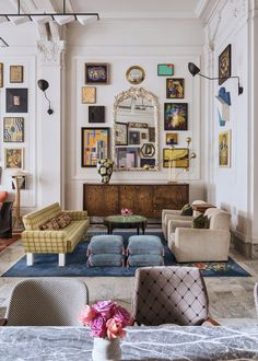 a living room filled with furniture and pictures on the wall