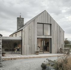 a wooden house sitting on top of a gravel field