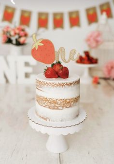 a cake with strawberries on top sitting on a table