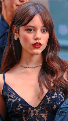 a close up of a person with long hair and wearing a blue dress at an event