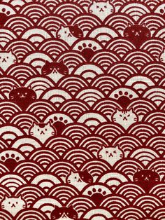 a red and white pattern on fabric with waves in the middle, as well as cats