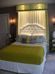 a green and white bed in a bedroom with two lamps on either side of the bed