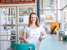 a woman standing in front of a blue table