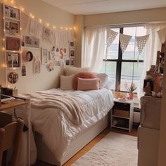 a bed room with a neatly made bed and lots of pictures hanging on the wall