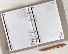 an open planner book sitting on top of a table next to a pen and pencil