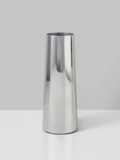 a silver vase sitting on top of a white table