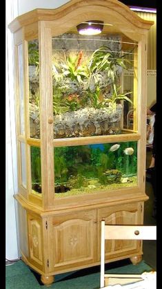 a fish tank sitting on top of a wooden cabinet next to a table with chairs