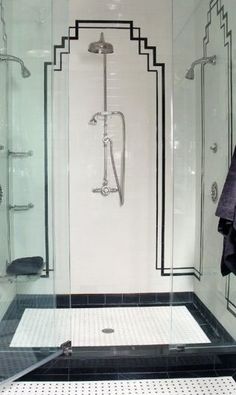 a bathroom with black and white tile flooring, shower stall and glass door to the bathtub