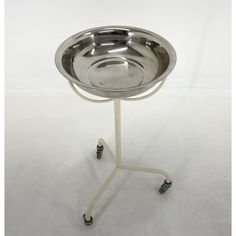 a metal tray on a white stand with wheels