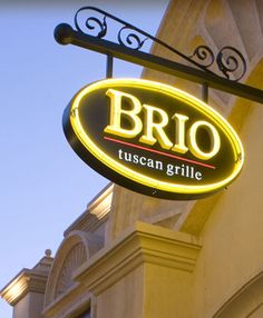 a restaurant sign hanging from the side of a building that says brio tuscan grille