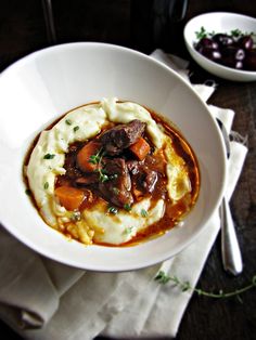 a white bowl filled with meat and mashed potatoes