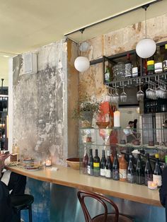 two people sitting at a bar with bottles on the counter